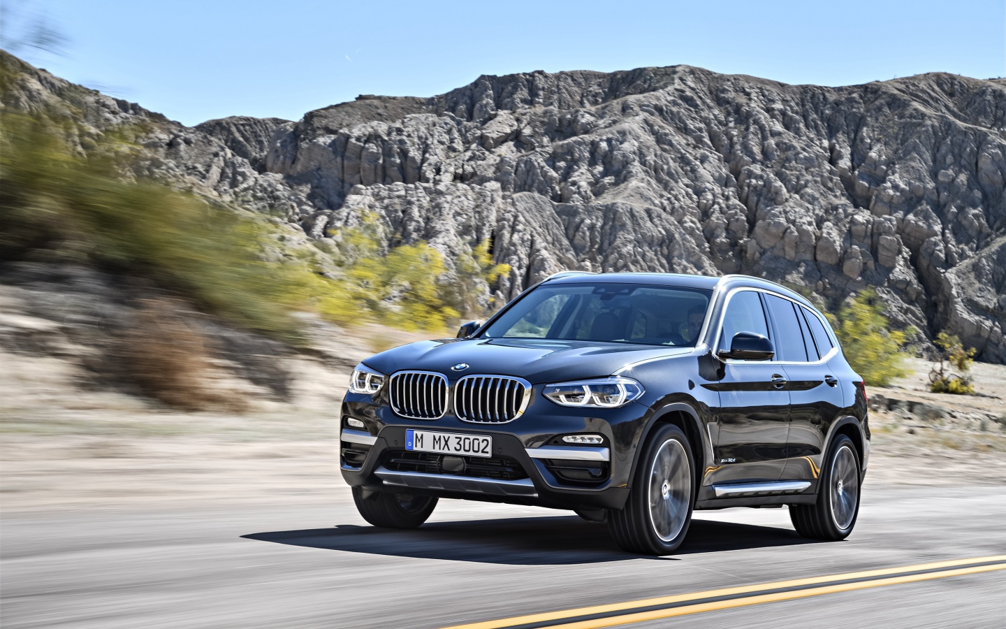 Черный красивый автомобиль BMW X3, 2018 на фоне гор