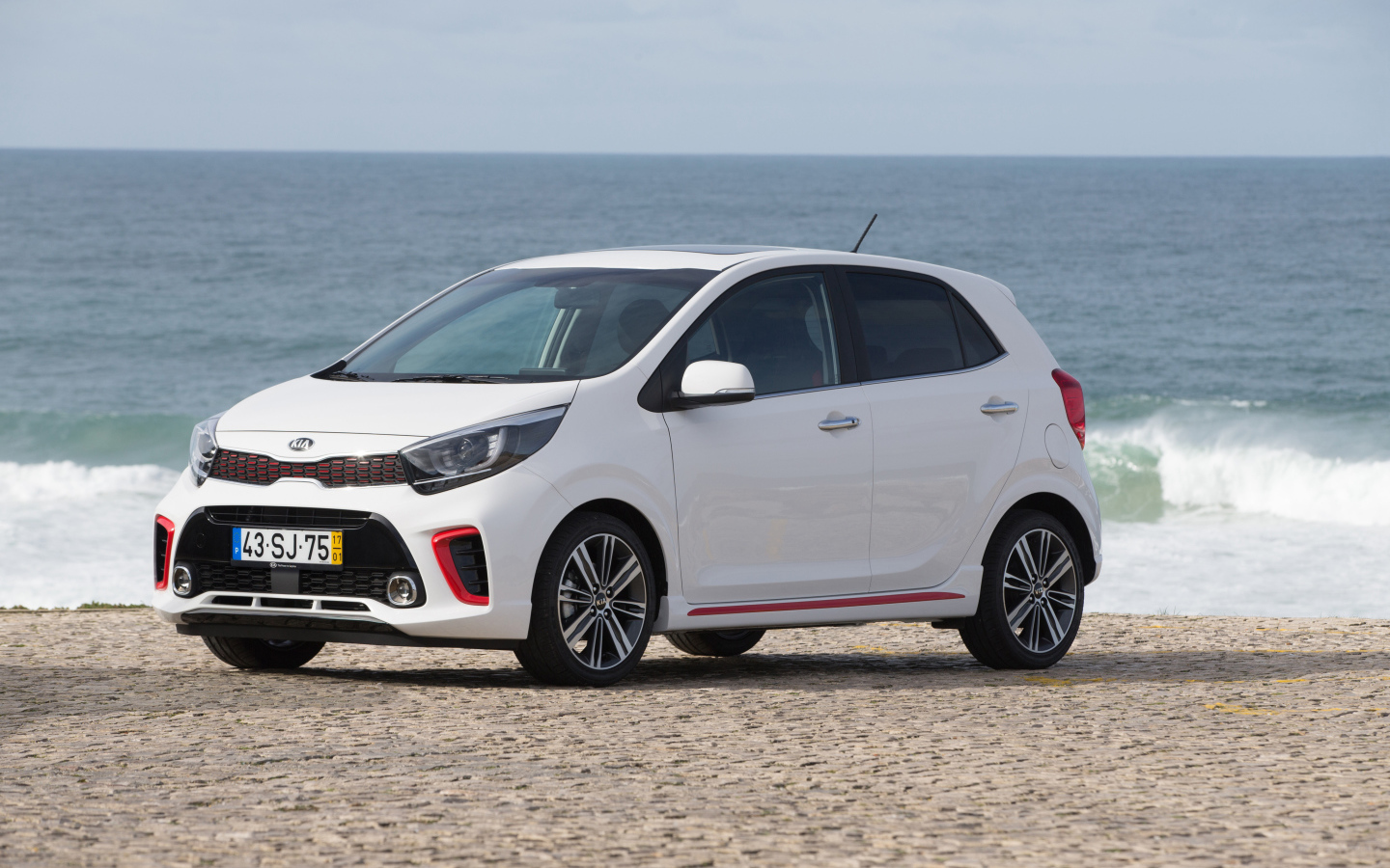 Белый автомобиль KIA Picanto GT Line, 2017 на фоне океана 