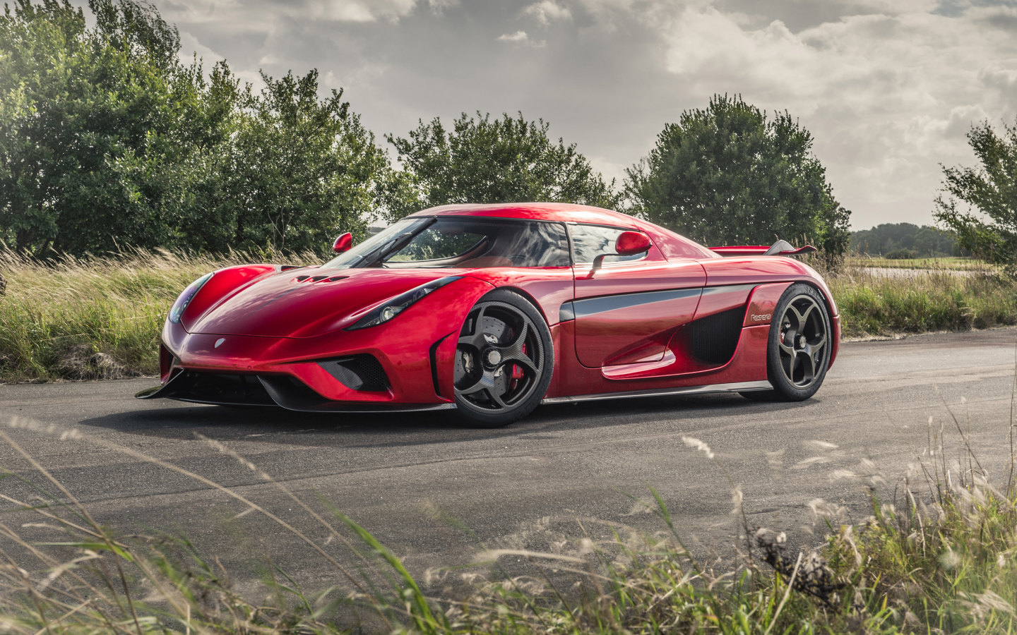 Красный спортивный автомобиль Koenigsegg Regera на дороге