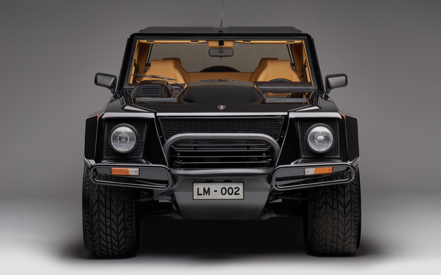 Черный автомобиль Lamborghini LM002 на сером фоне