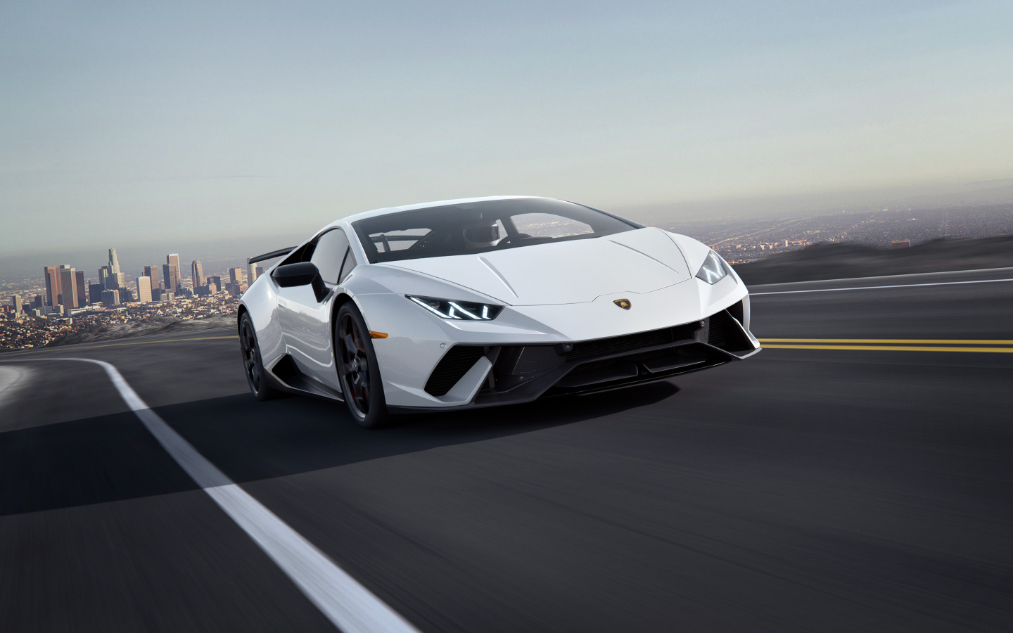 Белый спортивный автомобиль Lamborghini Huracan, 2018 на трассе