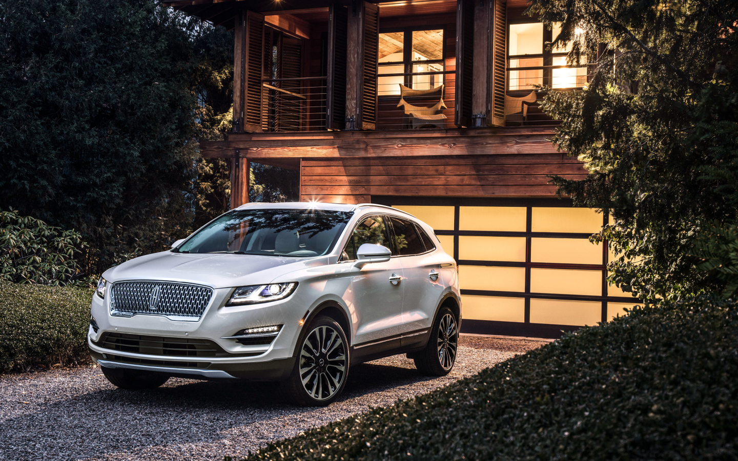 Серебристый автомобиль Lincoln MKC, 2019 у ворот гаража