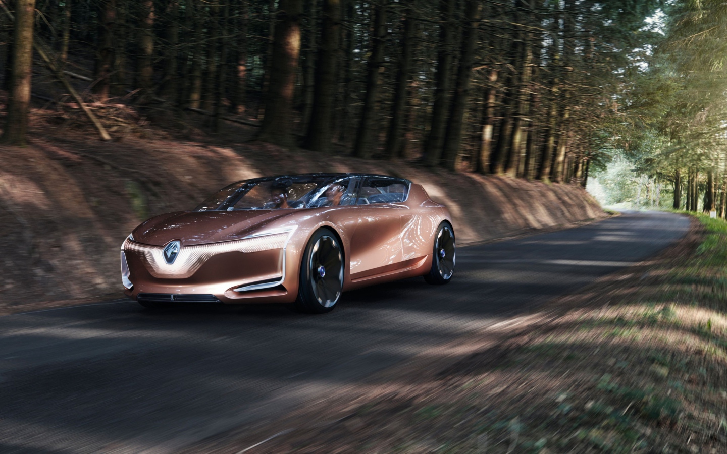 Коричневый электромобиль  Renault Symbioz на дороге в лесу