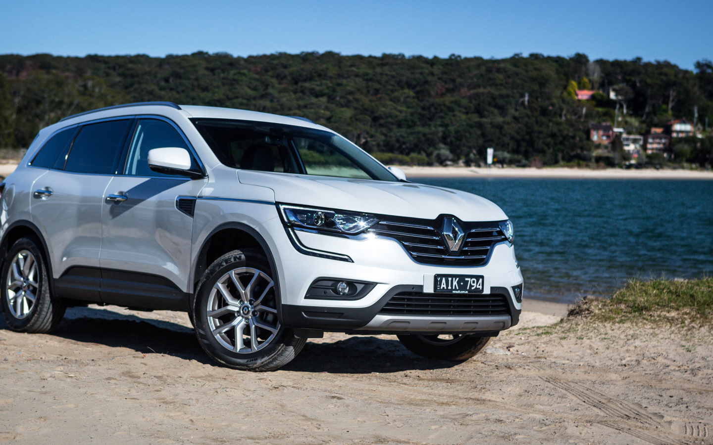Белый автомобиль Renault Koleos у водоема