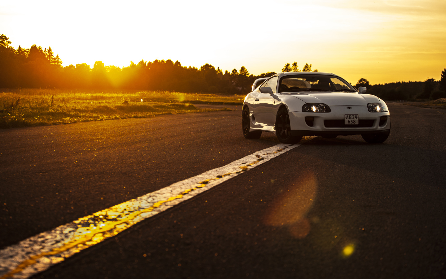 Белый автомобиль Toyota Supra стоит на трассе на рассвете