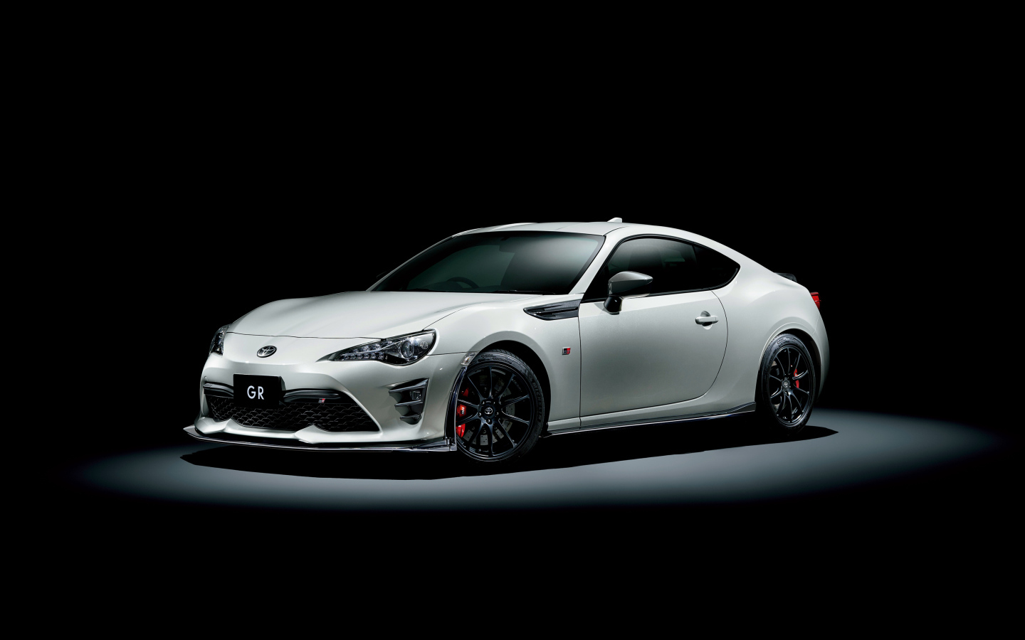 Белый спортивный автомобиль Toyota 86 GR на черном фоне