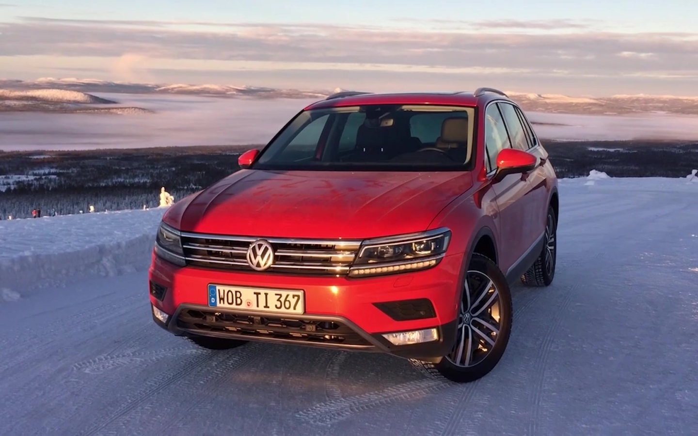 Красный Volkswagen Tiguan 2017 года на заснеженной трассе 