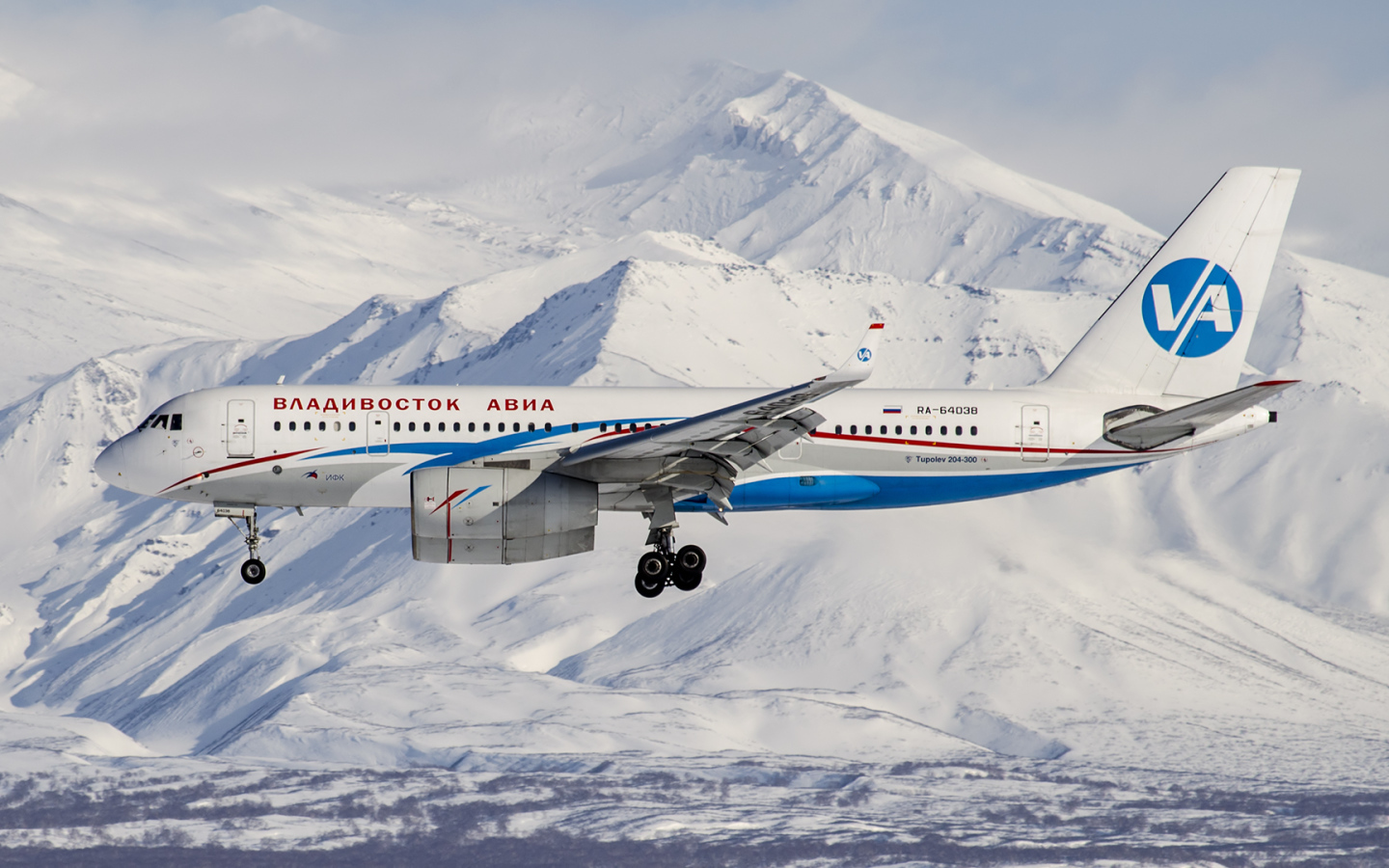 Самолет ТУ 204-300 авиакомпании Владивосток Авиа пролетает над горами Алтая 
