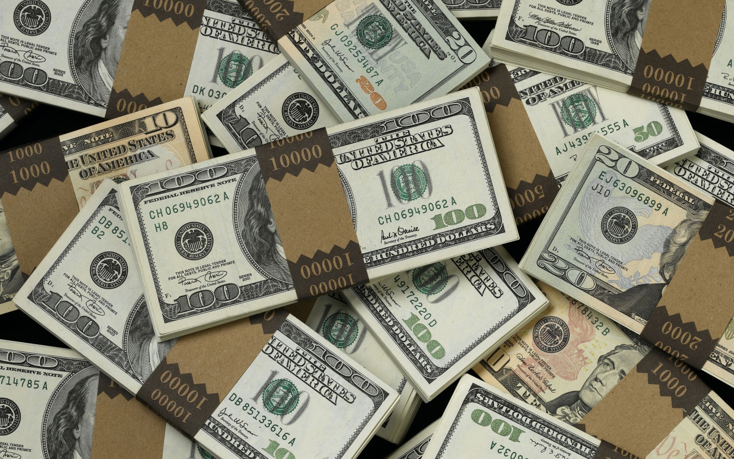 Много пачек купюр по сто долларов