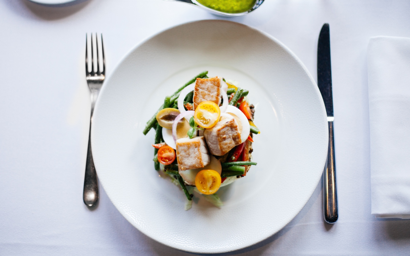 Овощной салат на белой тарелке со столовыми приборами