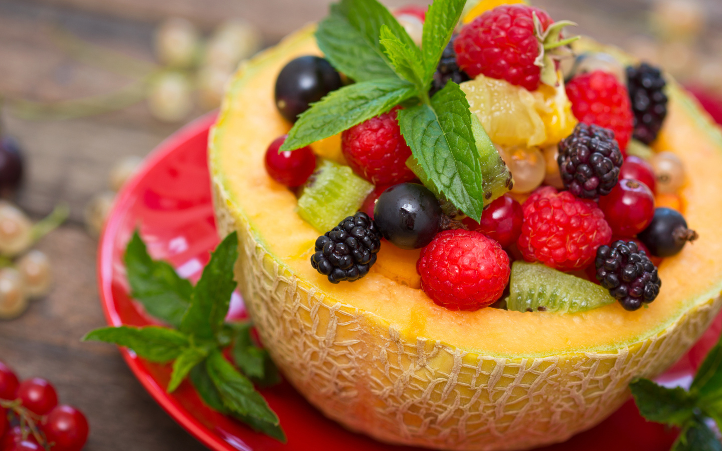 Аппетитные свежие ягоды с листьями мяты в половине дыни