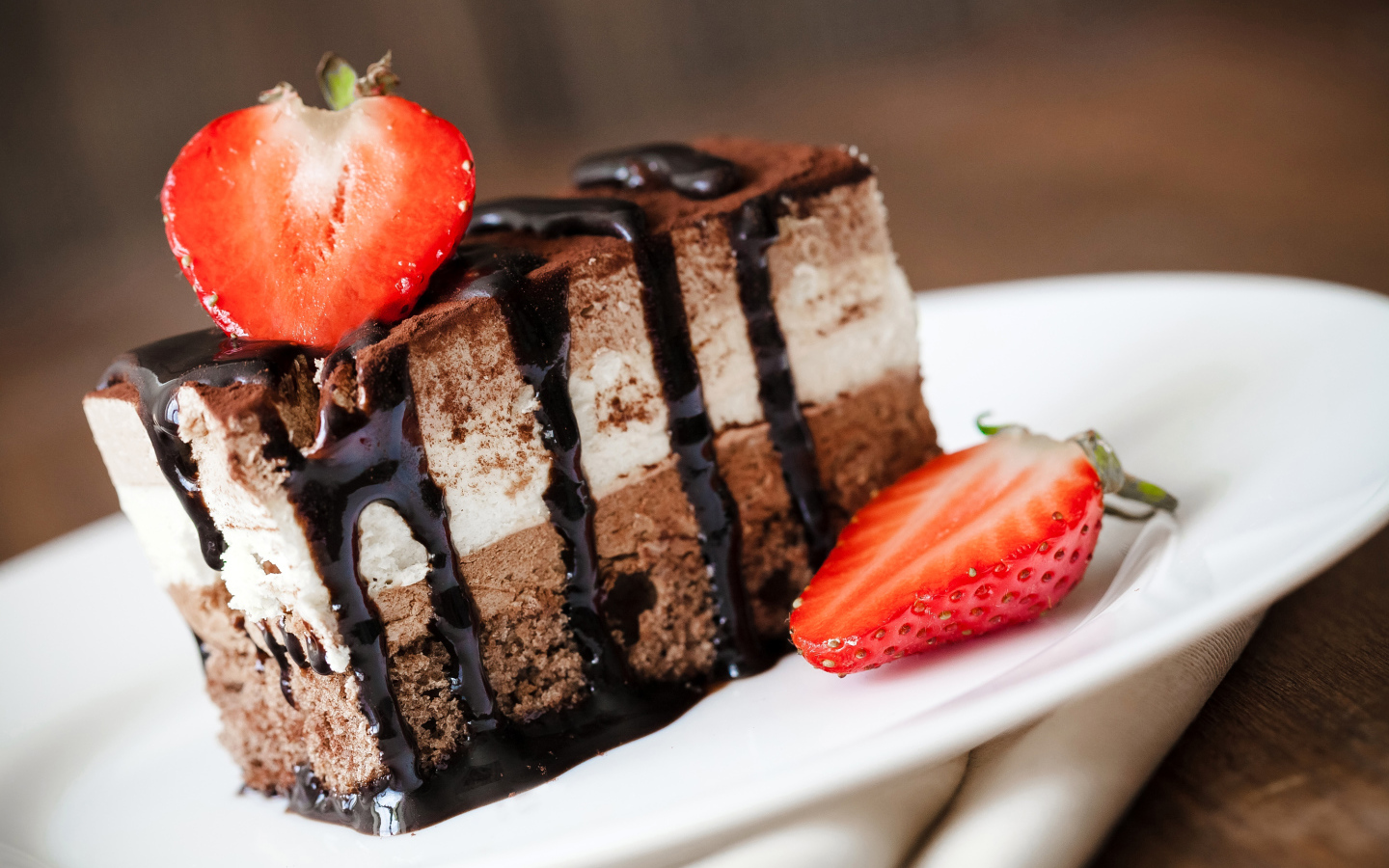 Кусок шоколадного пирожного со свежей клубникой