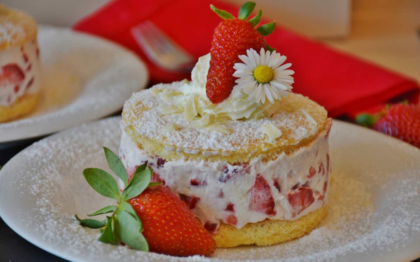 Торт со сливочным кремом и свежими ягодами клубники на белой тарелке