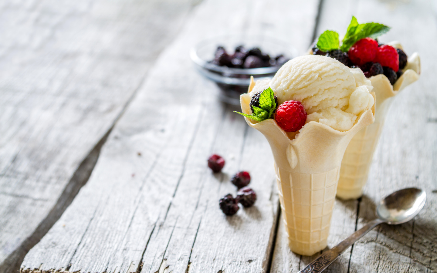 Сливочное мороженое в вафельном стаканчике с ягодами