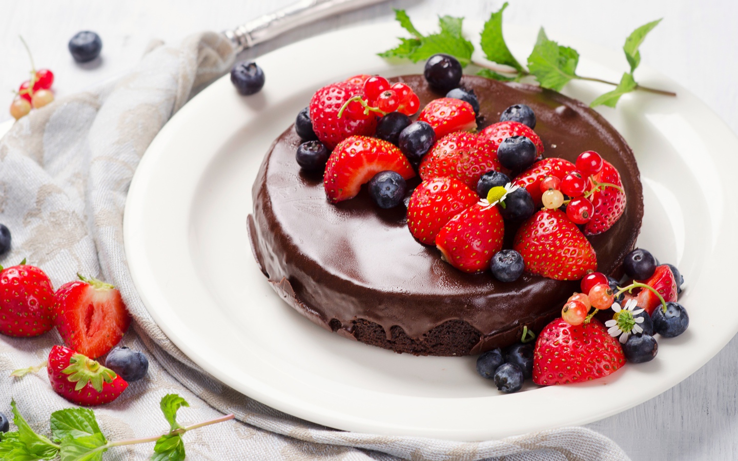 Вкусный торт в шоколаде с ягодами свежей клубники и черники