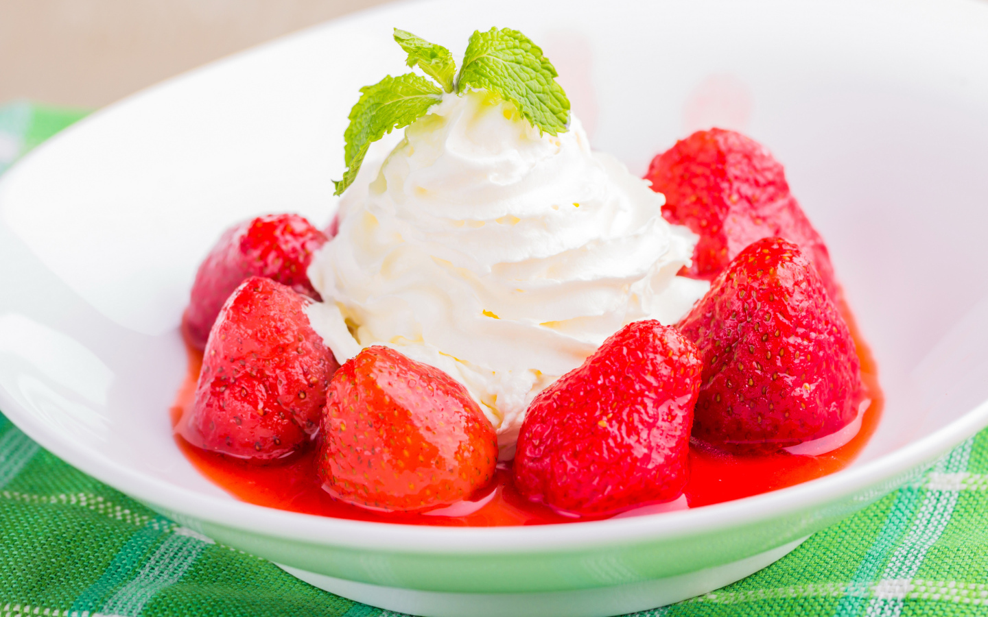 Вкусные сливки с клубникой на белой тарелке