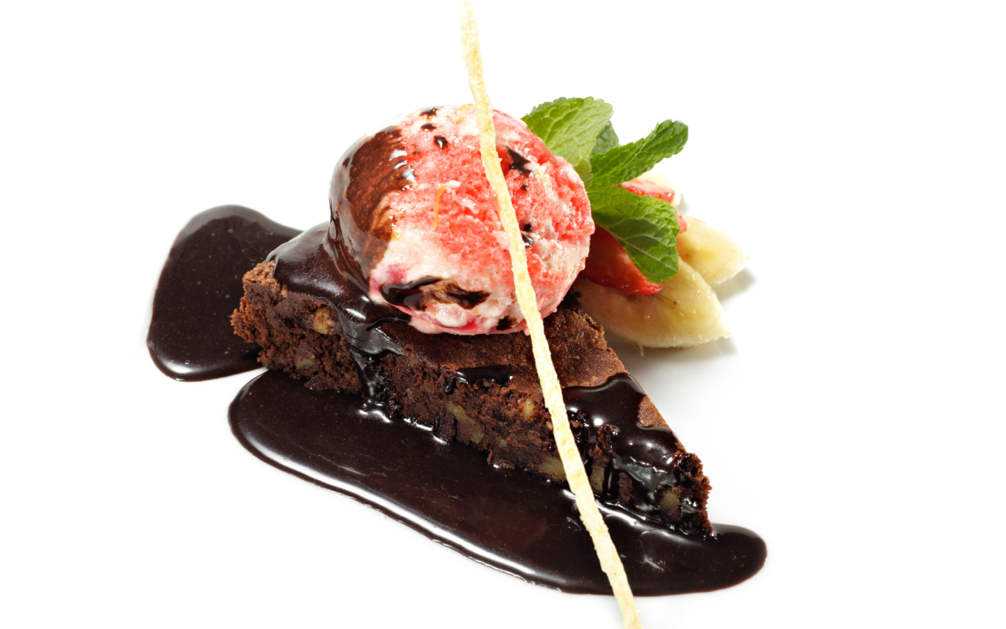 Кусок пирожного с шоколадом и шариком мороженого на белом фоне