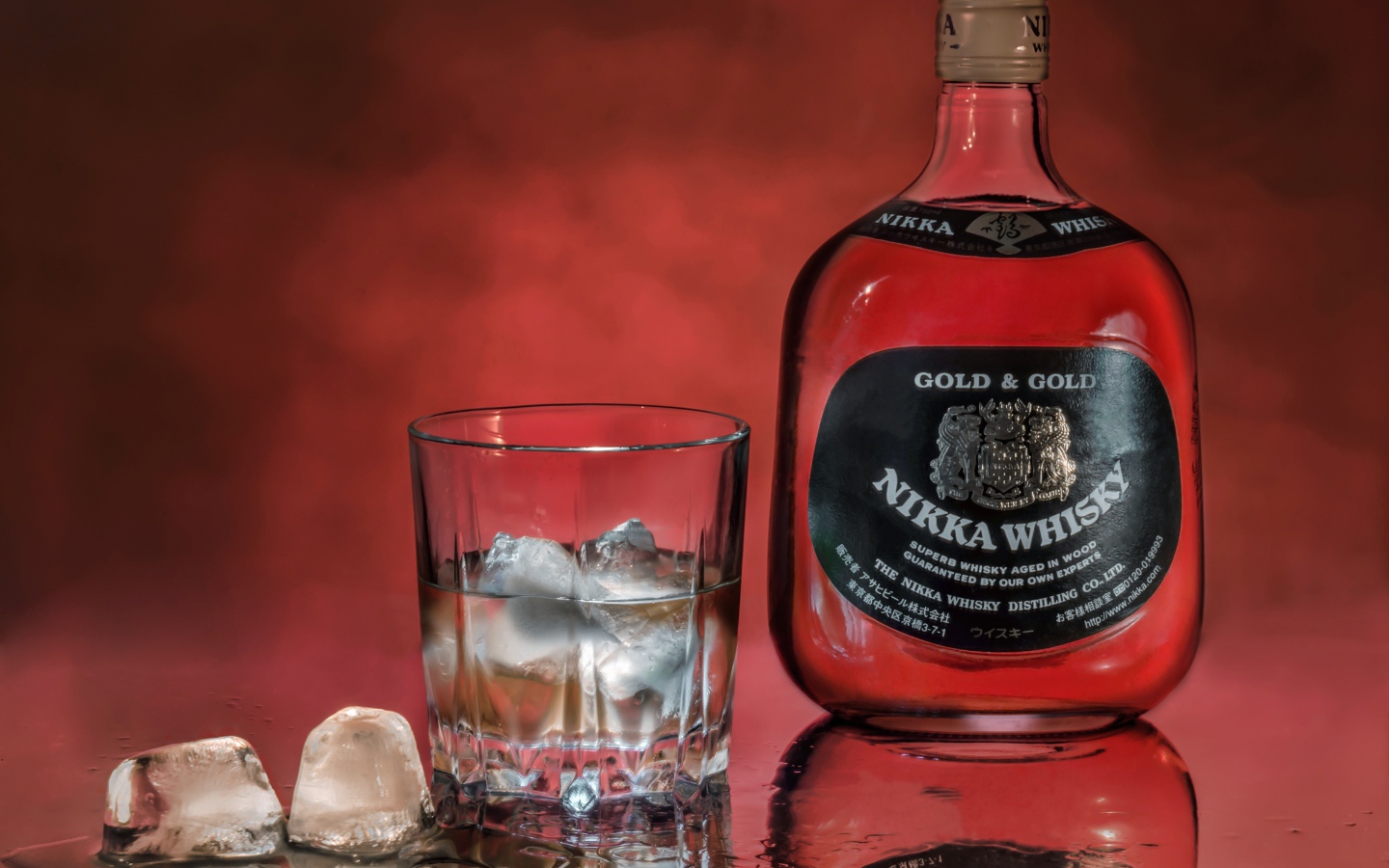 Бутылка Nikka Whisky на столе со стаканом со льдом