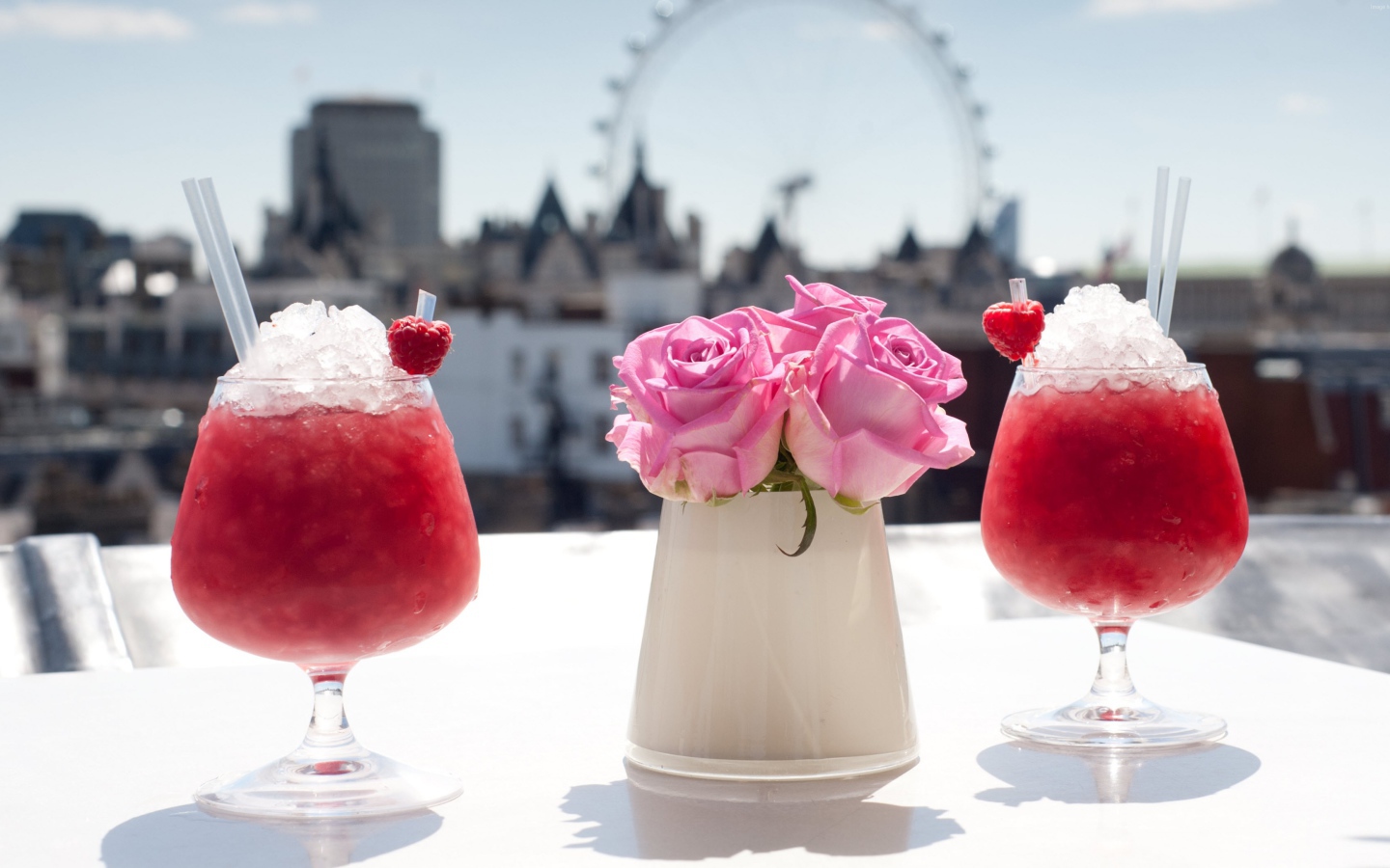 Два коктейля со льдом на столе с цветами