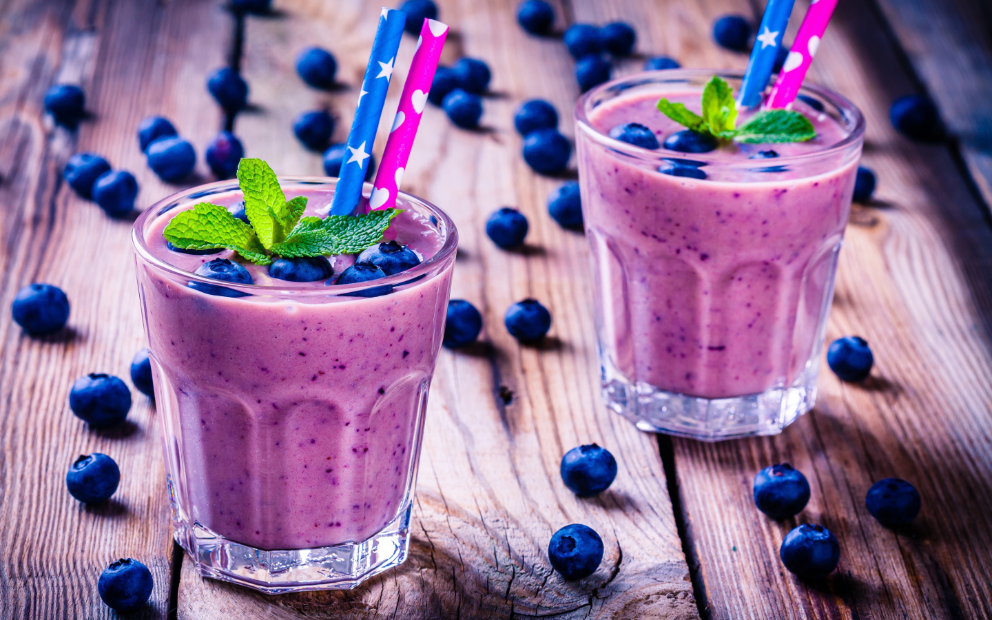 Два стакана черничного коктейля с трубочками