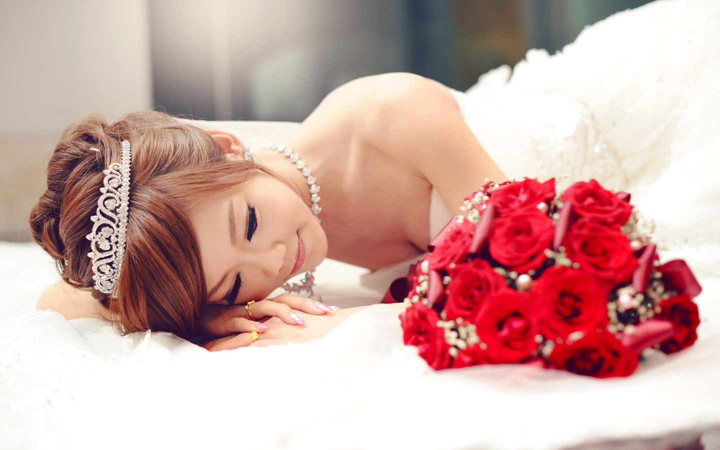 Красивая девушка азиатка в свадебном платье с букетом красных роз