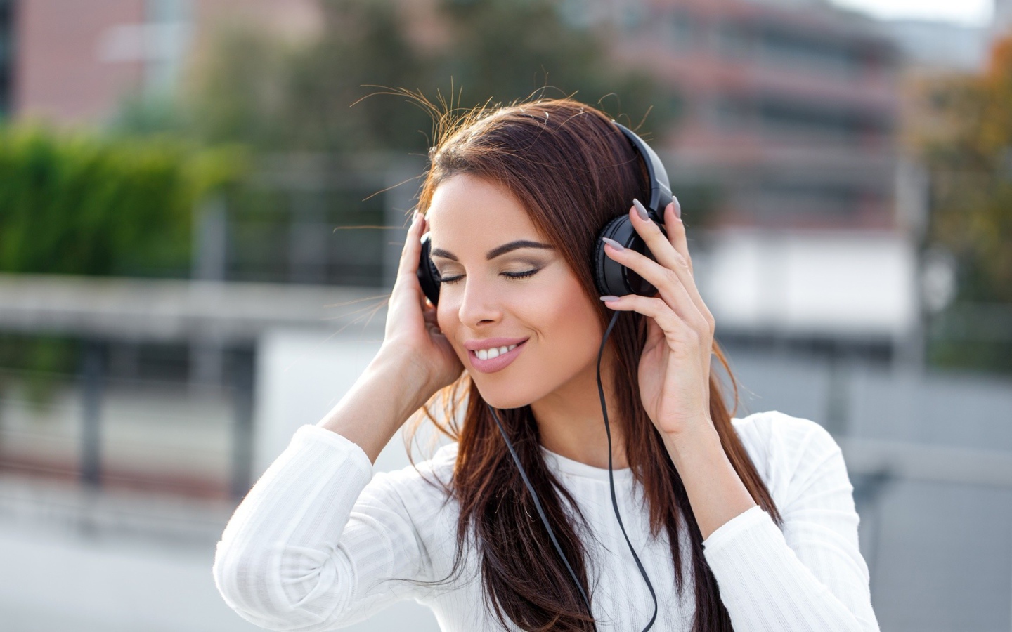 Красивая девушка брюнетка слушает музыку в наушниках 