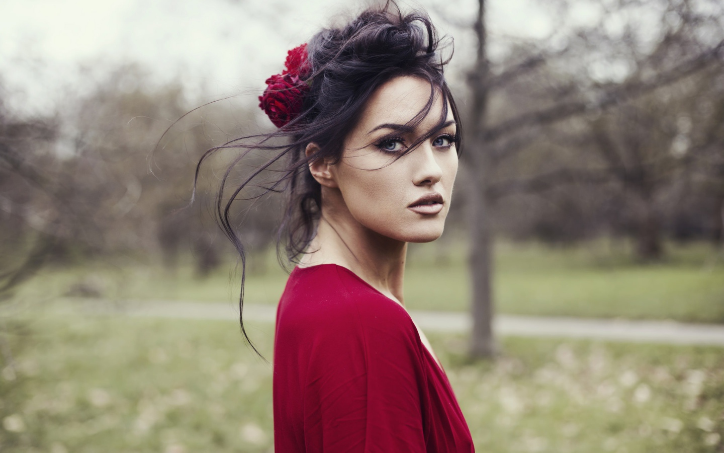 Красивая брюнетка в красном платье с цветком в волосах