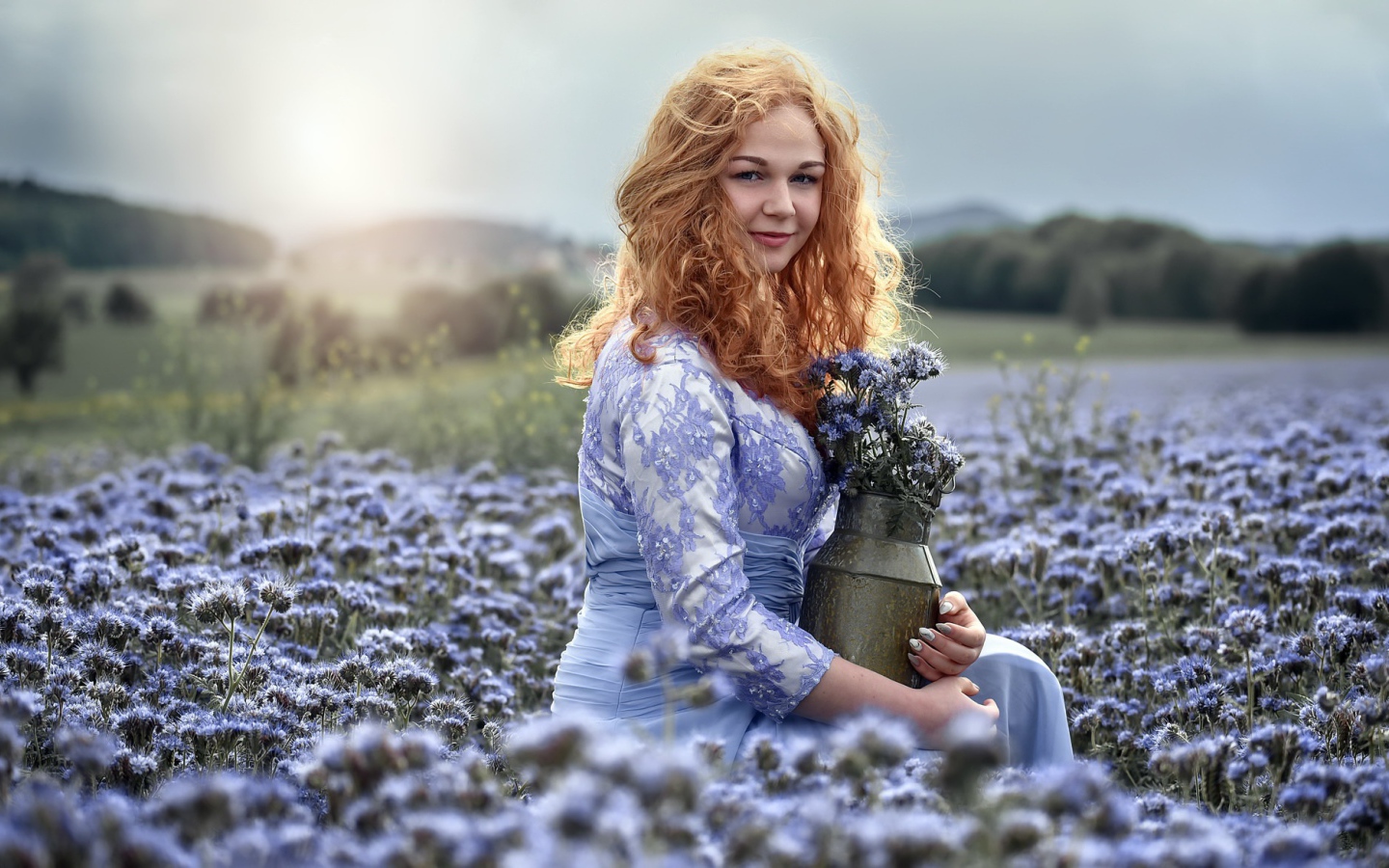 Красивая рыжеволосая девушка собирает цветы