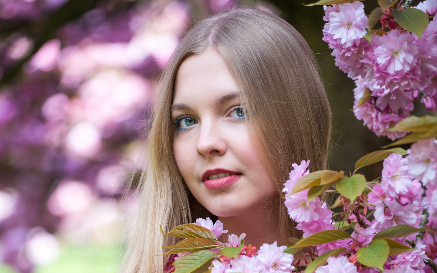 Милая голубоглазая девушка с розовыми цветами 