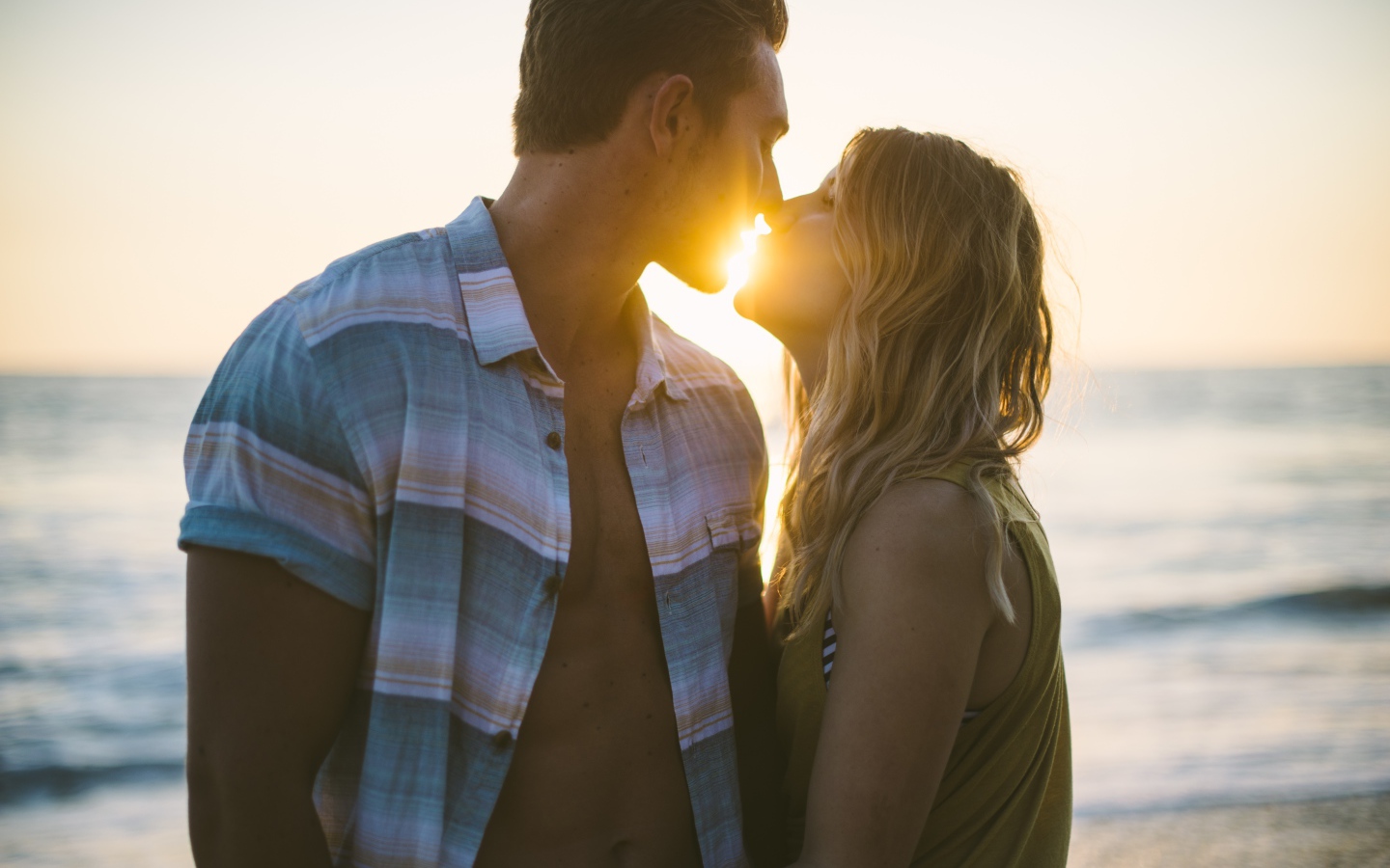 Романтический поцелуй влюбленной пары на закате солнца