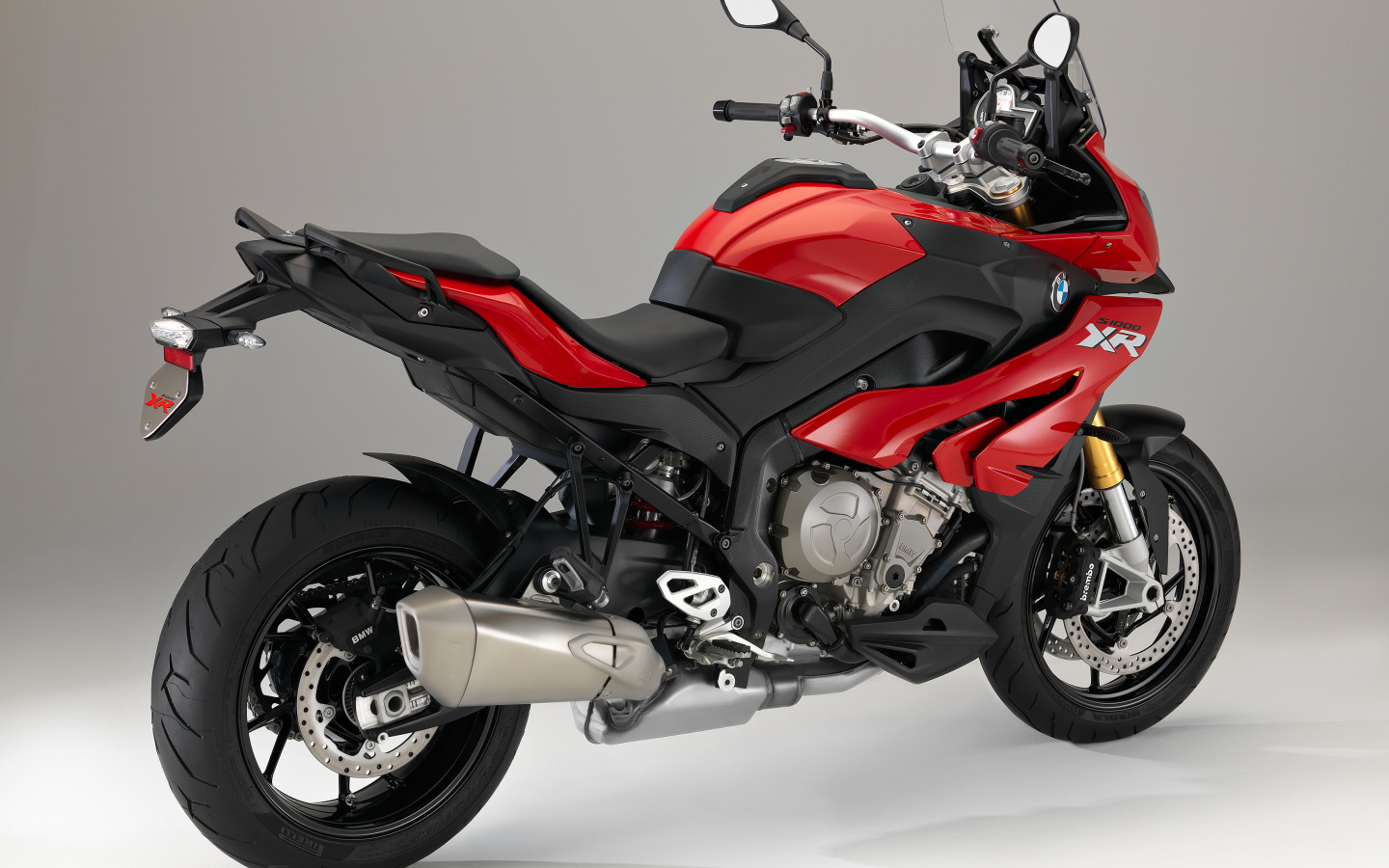 Красный мотоцикл BMW  S 1000 XR на сером фоне
