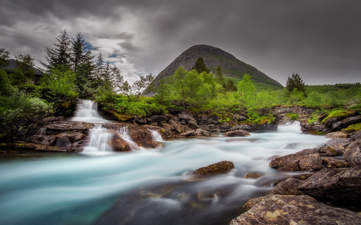 Быстрая вода в горной реке с маленьким водопадом 