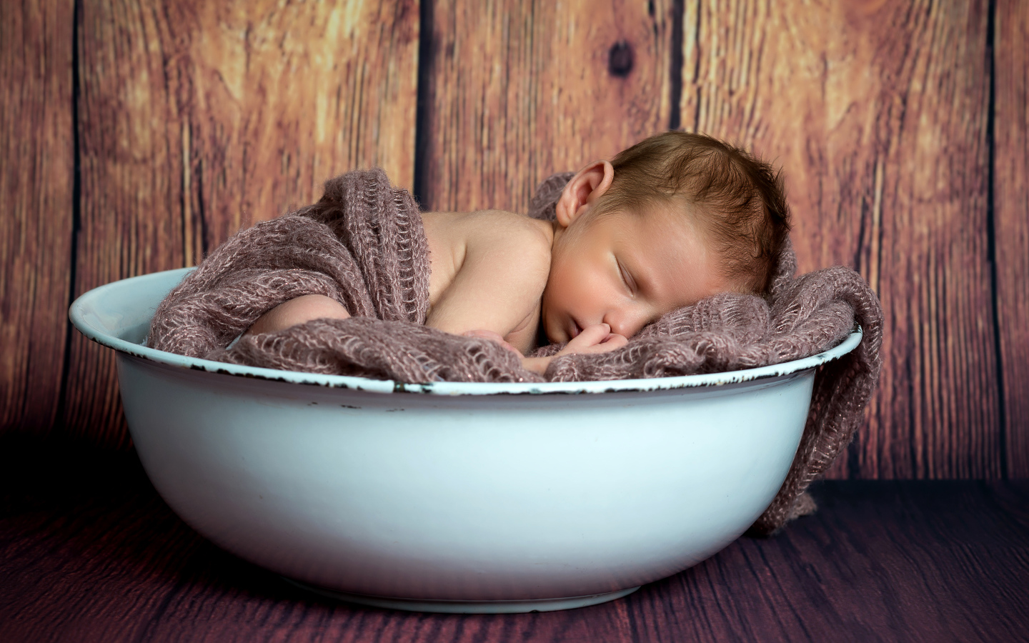 Новорожденный ребенок спит в белой миске