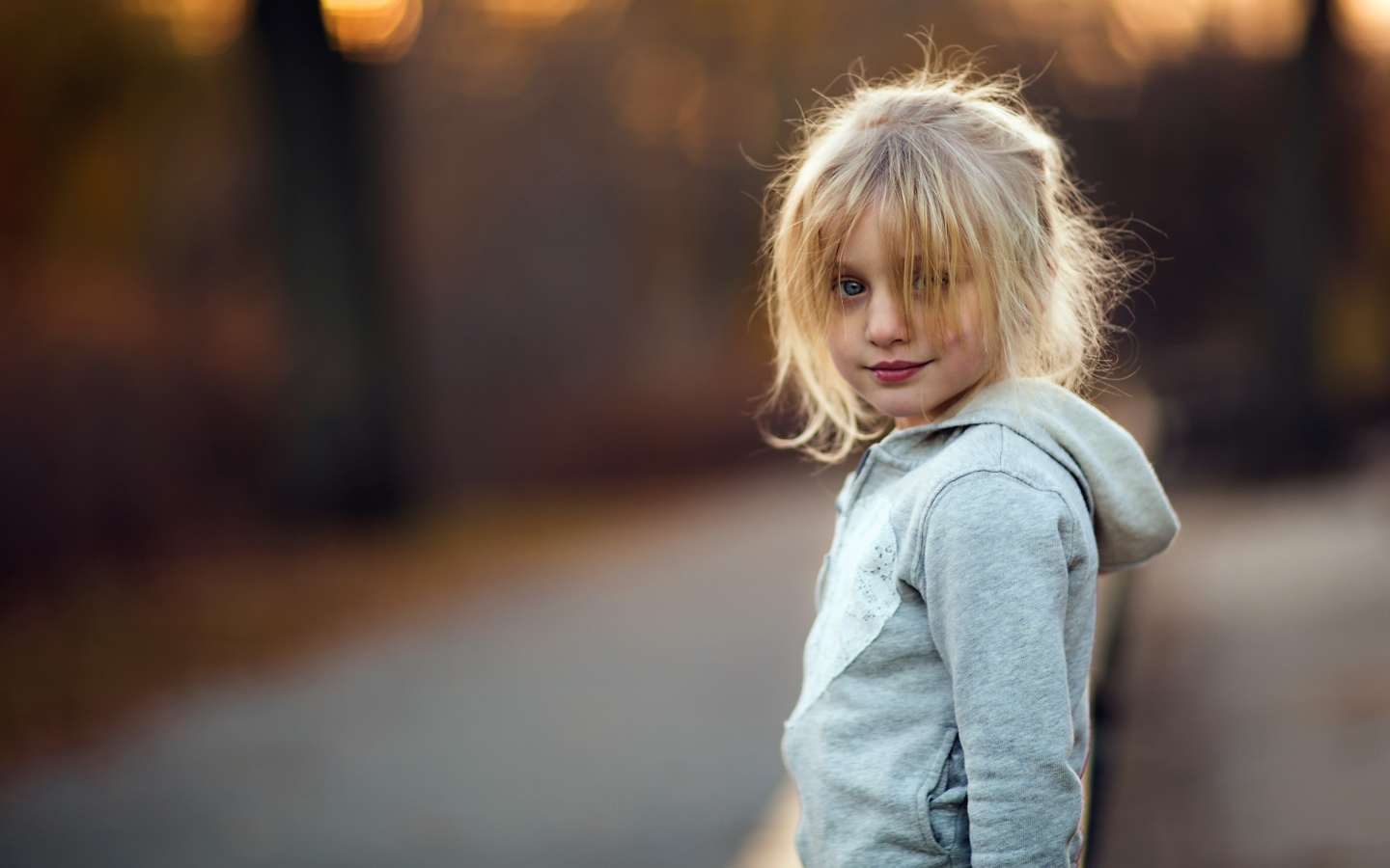 Маленькая девочка блондинка в серой кофте