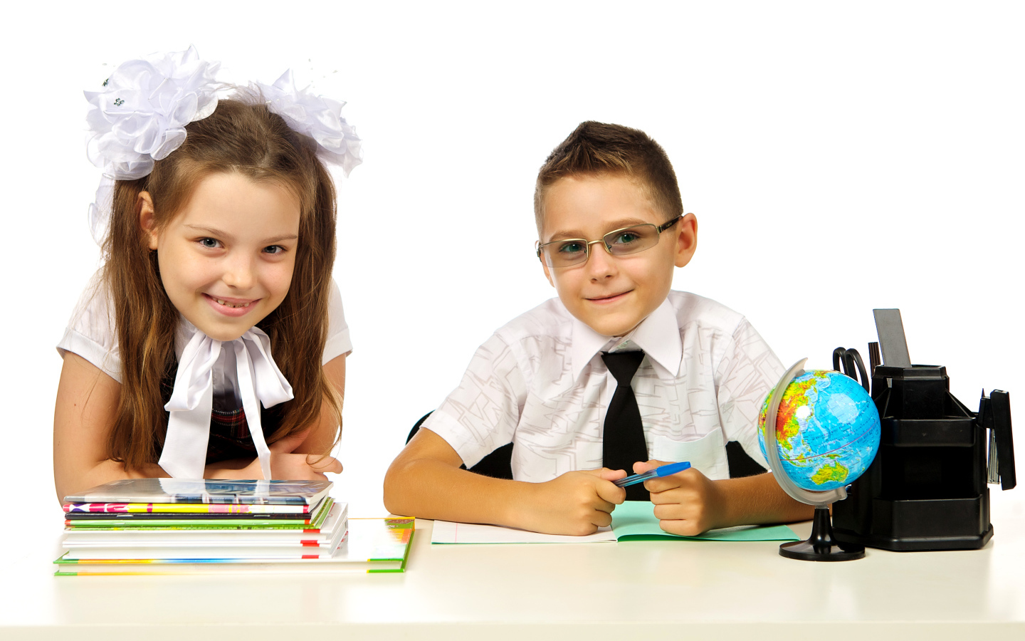 Маленькие мальчик и девочка школьники на белом фоне