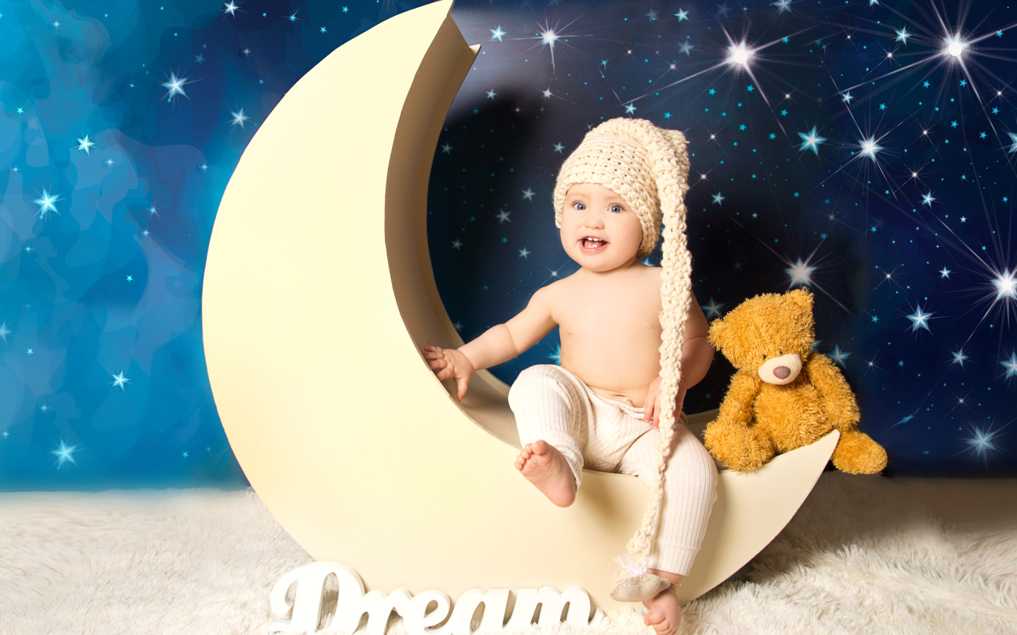 Маленький мальчик с плюшевым мишкой сидят на месяце