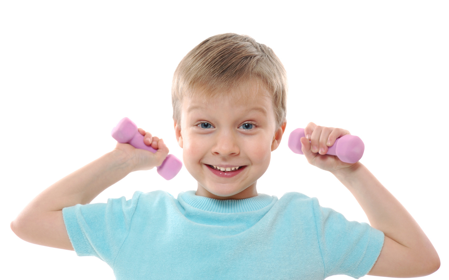 Маленький улыбающийся мальчик с гантелями на белом фоне