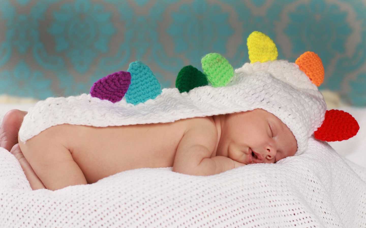 Спящий младенец в белой вязаной накидке