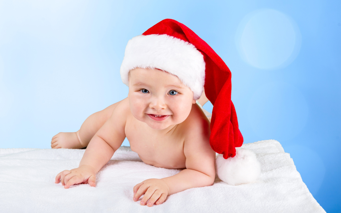 Улыбающийся грудной ребенок в новогодней шапке