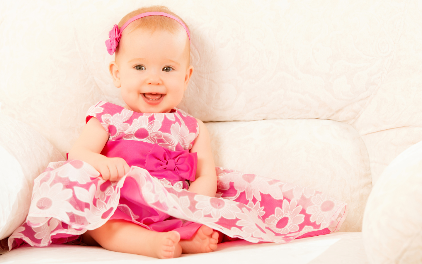 Улыбающаяся маленькая девочка в красивом розовом платье