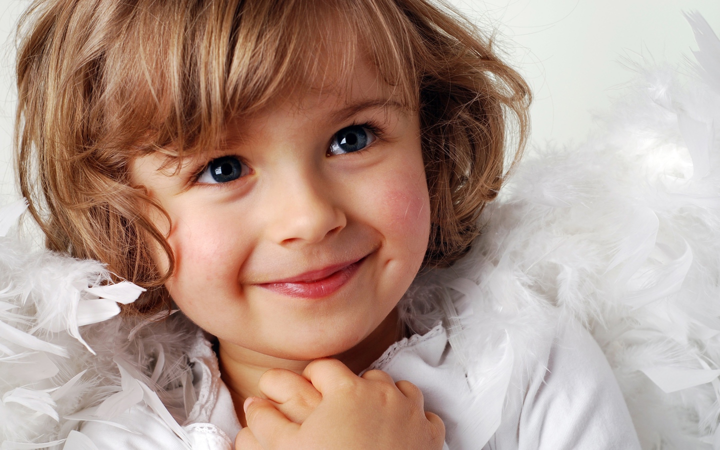 Маленькая голубоглазая девочка в костюме ангела 