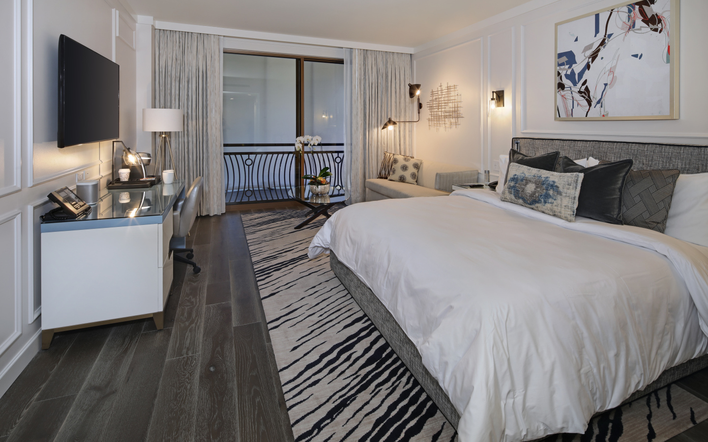 Спальня с большой кроватью и телевизором на стене