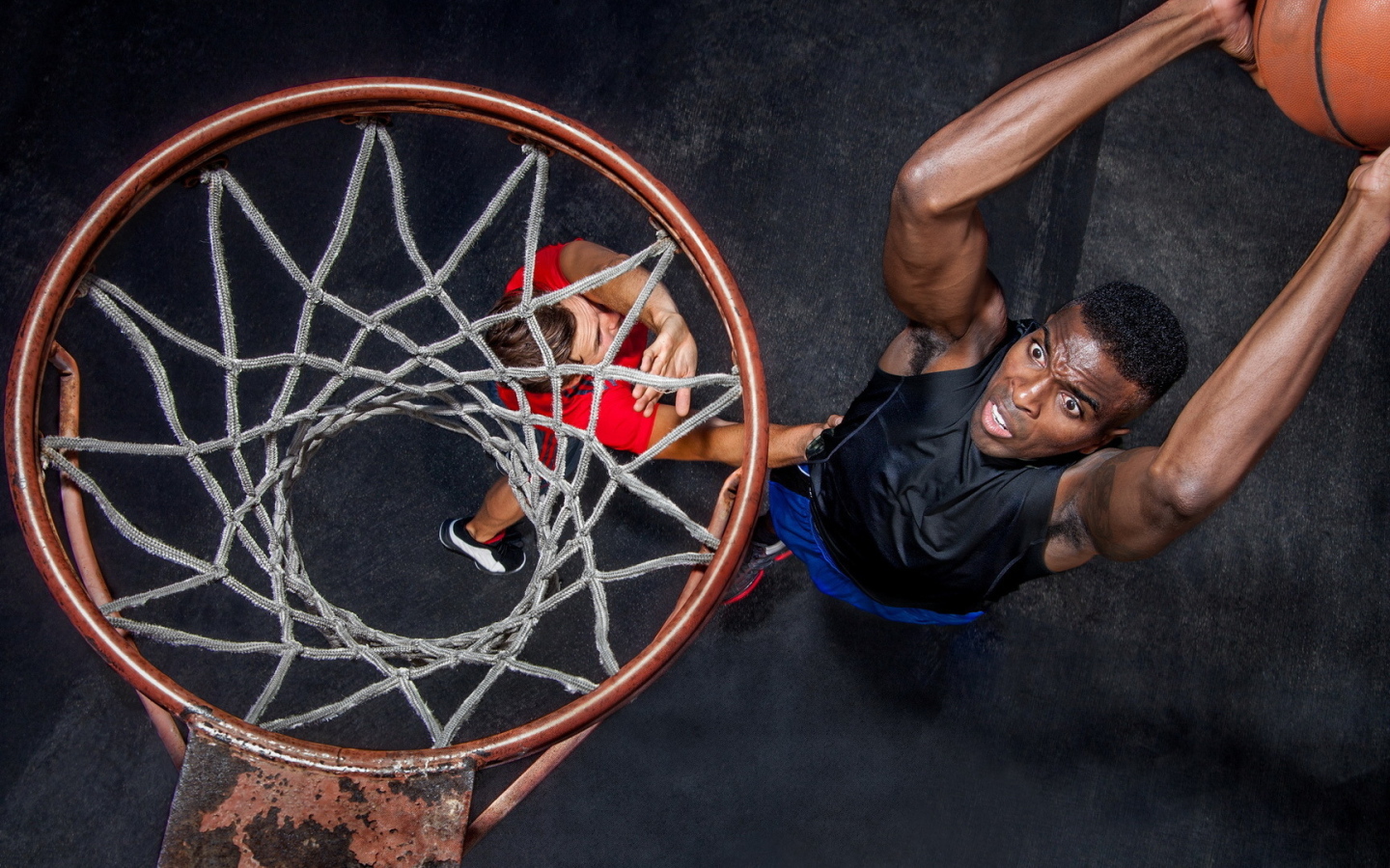 Баскетболист забрасывает мяч в кольцо 