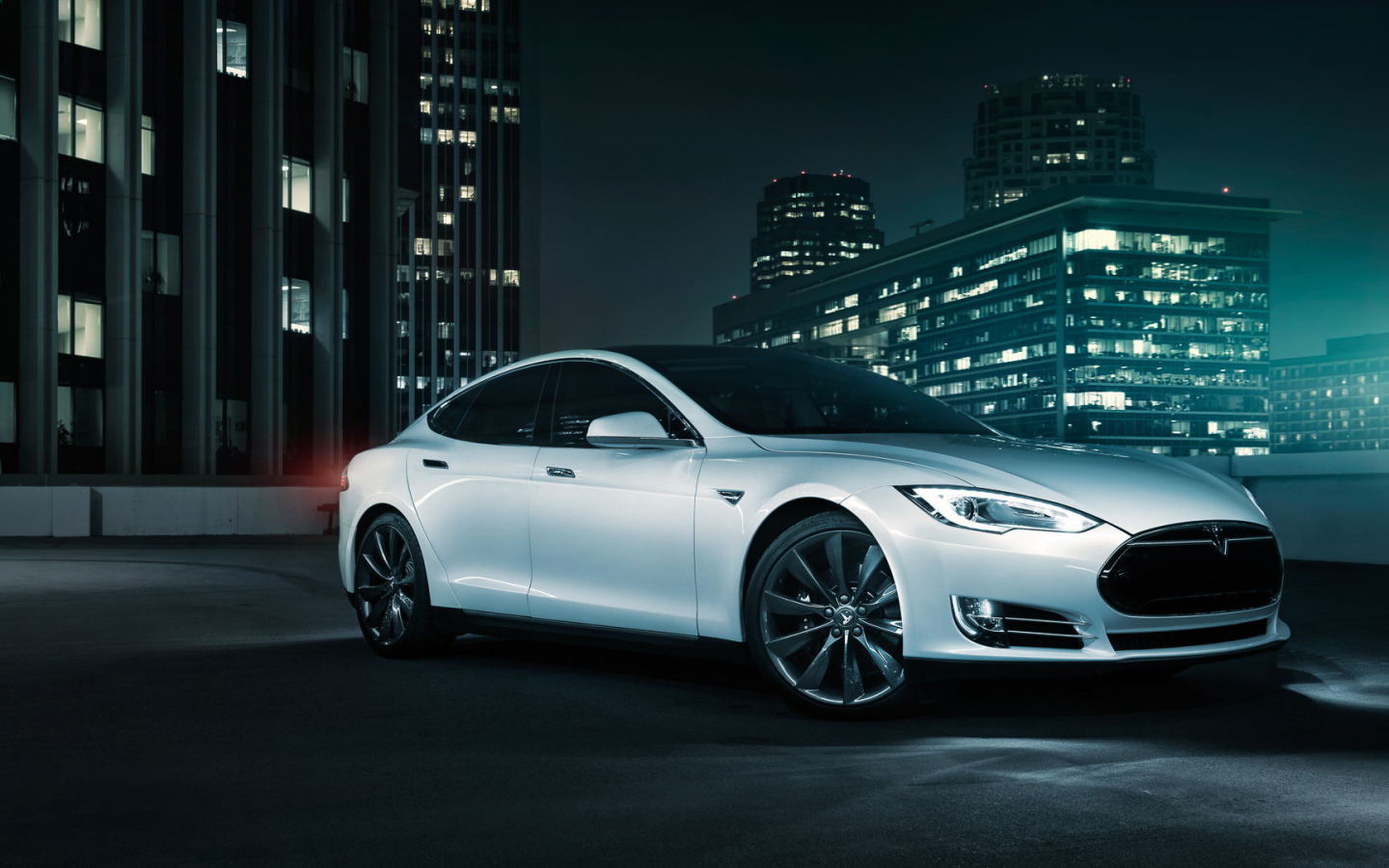 Белый электромобиль Тесла на фоне города 