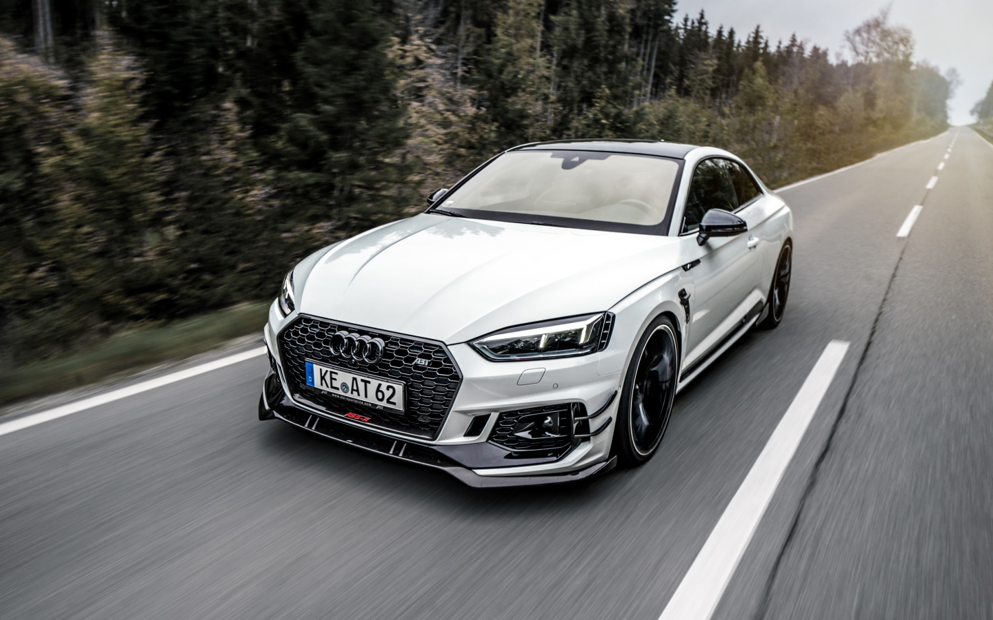 White car Audi RS5 2018 on the road near the forest