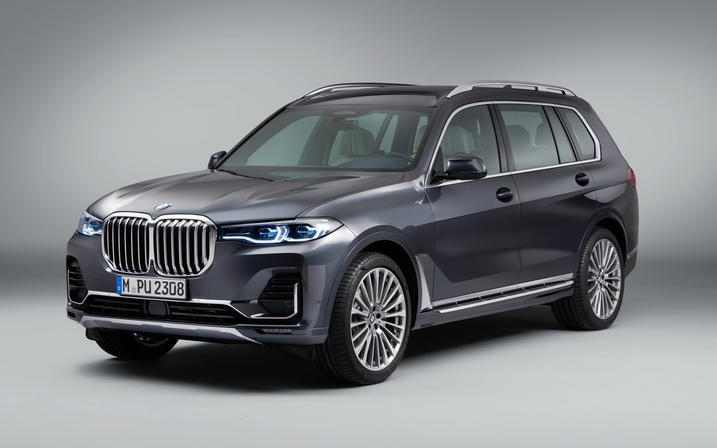 Серебристый внедорожник BMW X7, 2018 года на сером фоне