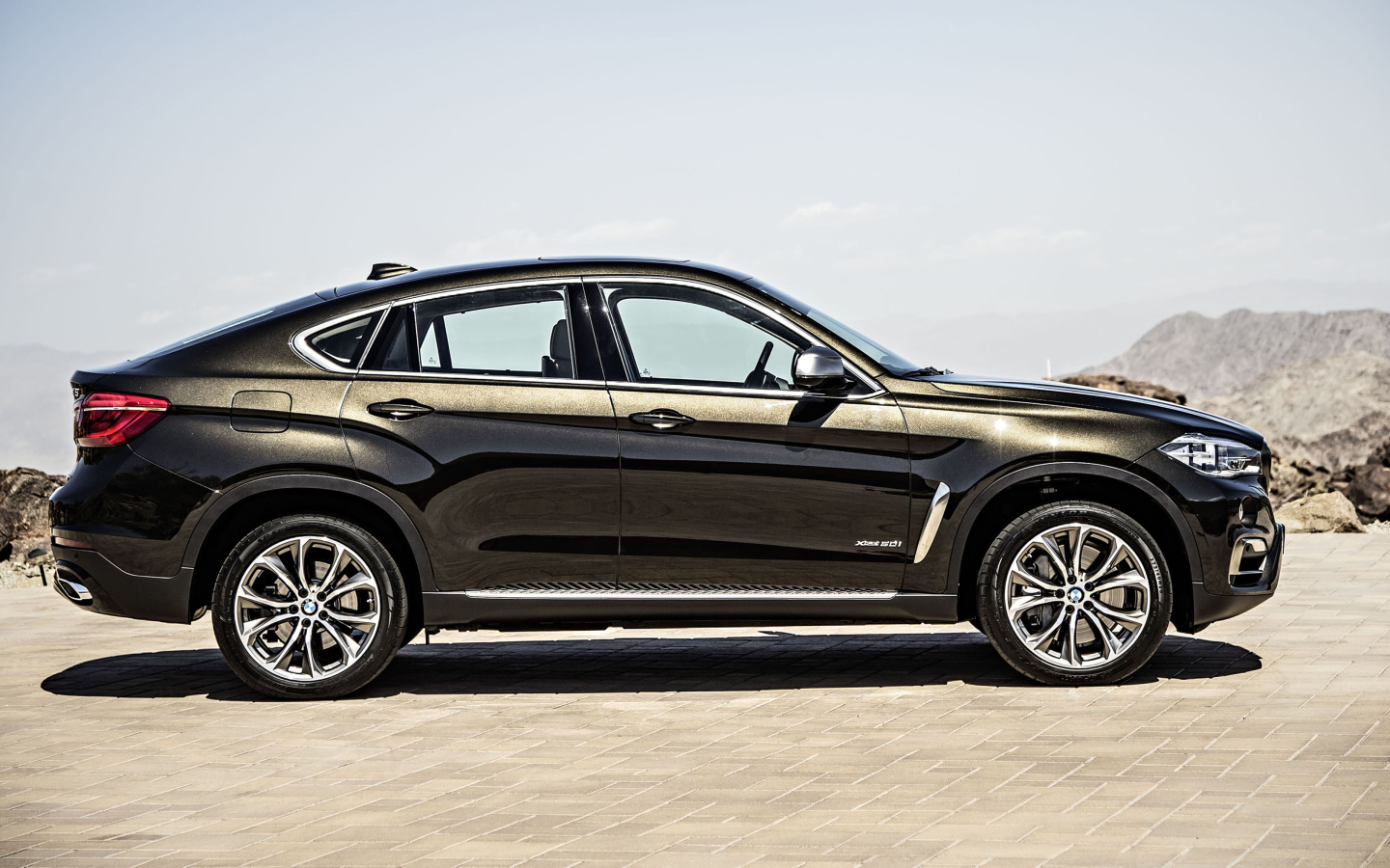 Черный автомобиль BMW X6, 2018 года вид сбоку