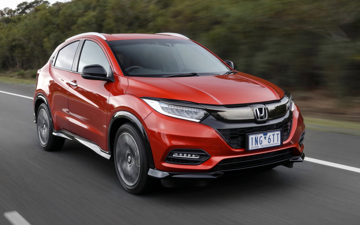 Красный автомобиль Honda HR-V RS 2019 года на трассе