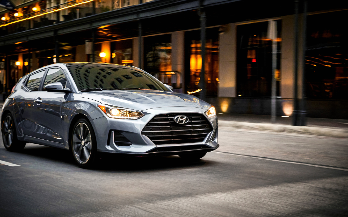 Silver car Hyundai Veloster, 2019 with headlights on