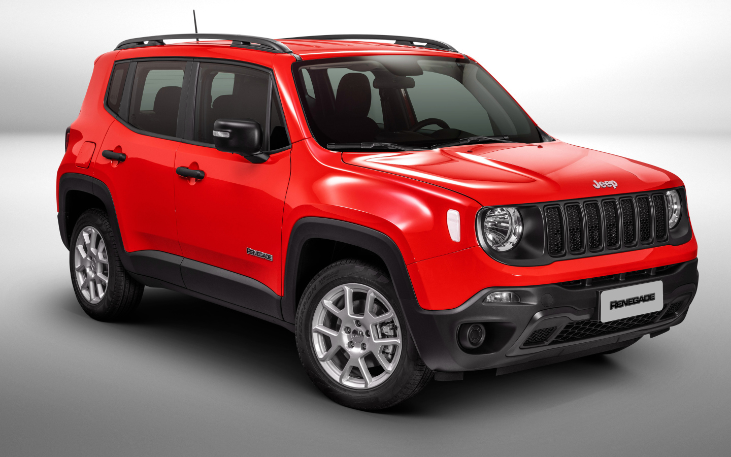 Красный автомобиль Jeep Renegade Sport на сером фоне